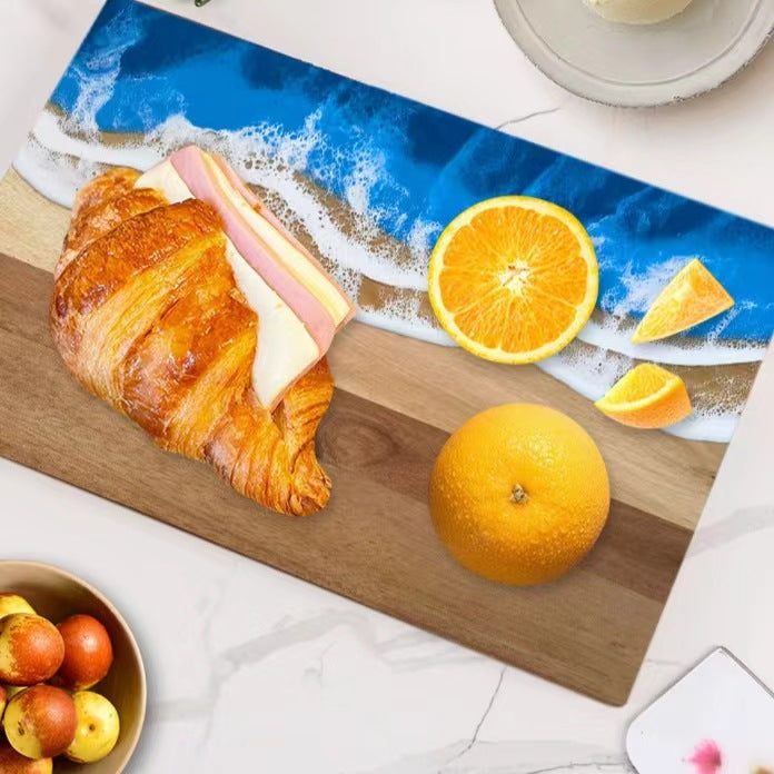 Wood and resin cutting board with blue ocean epoxy edge croissant and orange on board on Tampa Home & Garden Store