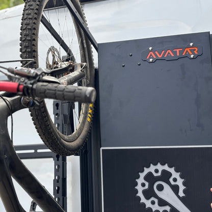 Avatar Centi Van Storage Box in dark gray metal with Avatar logo, mounted on a bike rack on Tampa Home & Garden Store