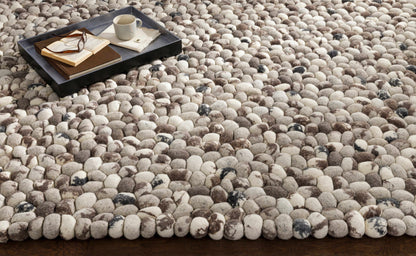 Fillmore Area Carpet by Boutique Rugs, pebble-textured rug in beige, with a tray of books on Tampa Home & Garden Store