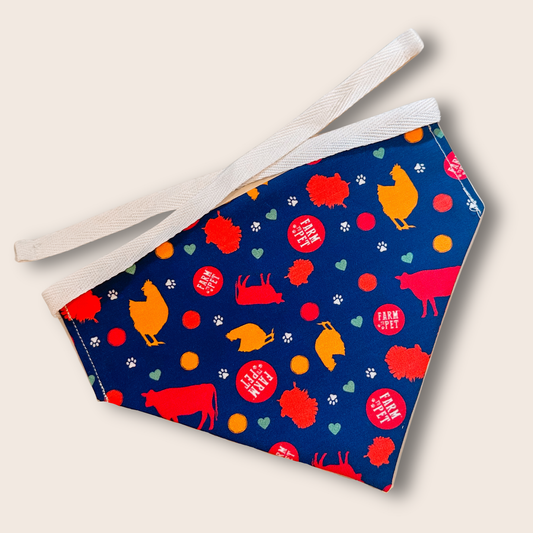 Tie-on dog bandana by Farm To Pet, blue with colorful dogs and paw prints; white adjustable ties on Tampa Home & Garden Store