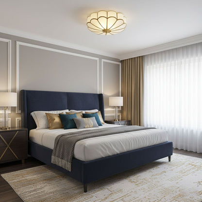 Flower-shaped frosted glass ceiling light with brass frame over a navy bed in a modern bedroom on Tampa Home & Garden Store