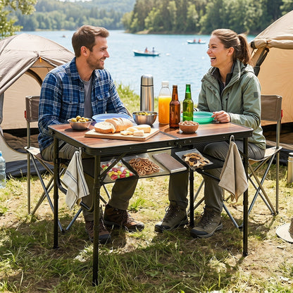 GemGear folding camping table with adjustable height and storage nets at a lakeside picnic on Tampa Home & Garden Store