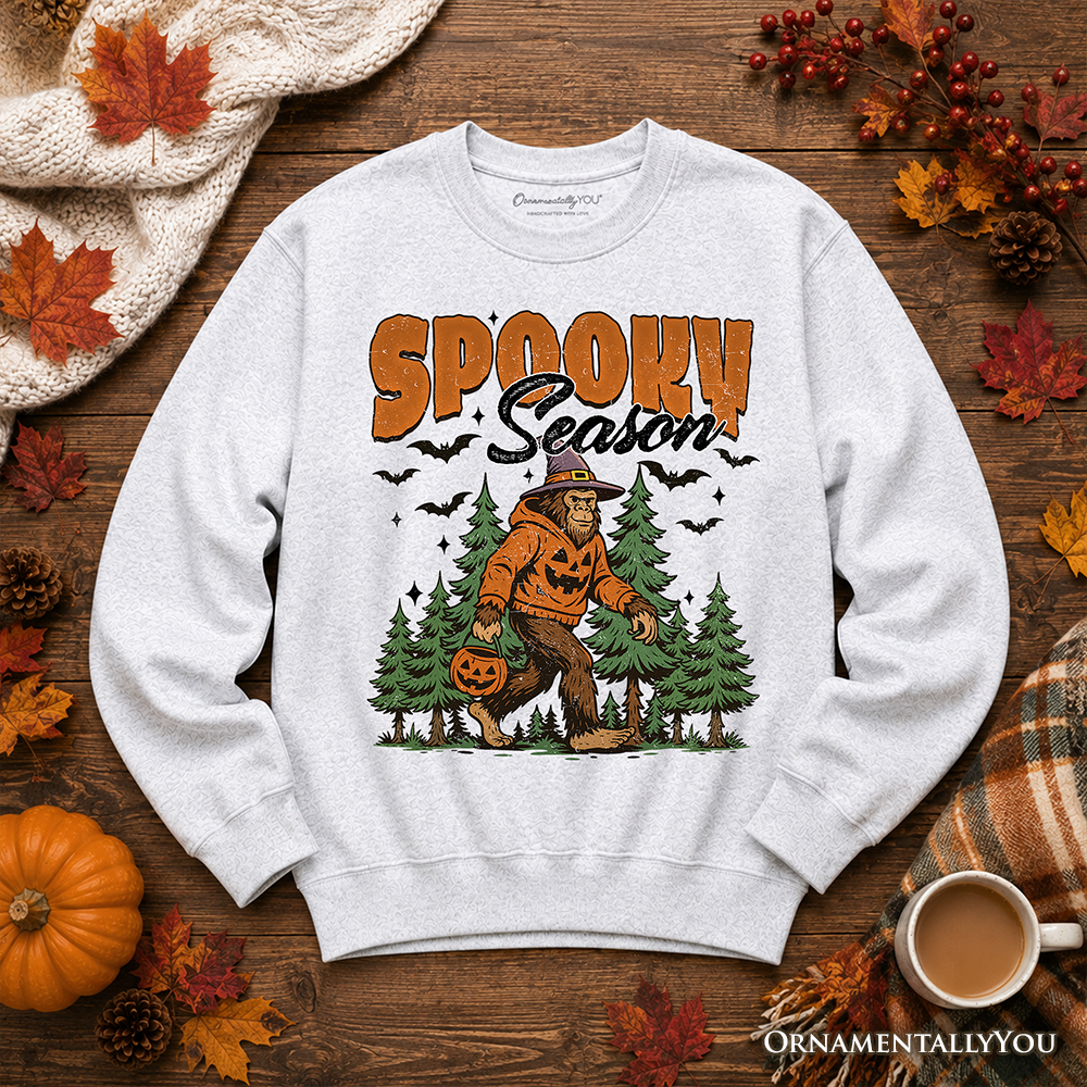 Sweatshirt Spooky Season Bigfoot with orange pumpkin Sasquatch on gray heather OrnamentallyYou on Tampa Home & Garden Store