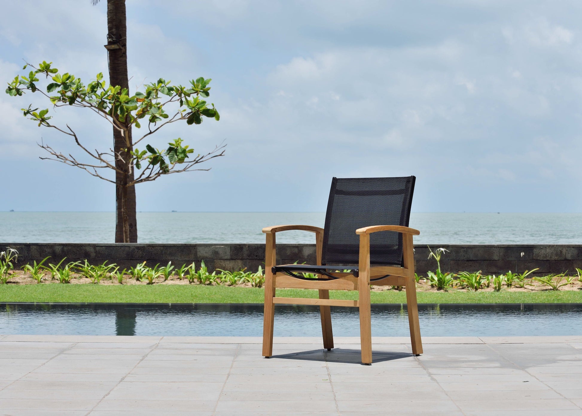 Rinjani rectangular teak table with Fortuna armchair poolside setting teak and black mesh on Tampa Home & Garden Store