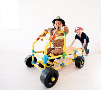 TubeLox Deluxe Set STEM toy colorful tube construction wagon; kids in firefighter costumes play on Tampa Home & Garden Store