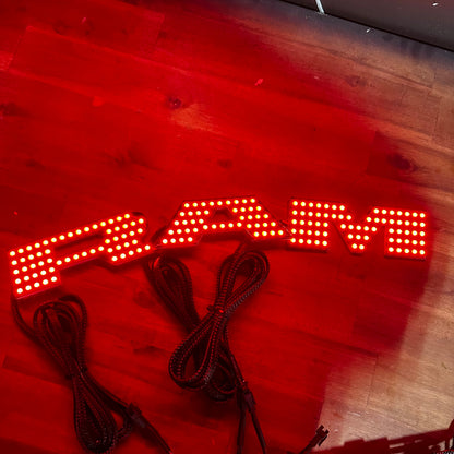 RAM RGBW Flow badge emblem with red LED panels and braided cords interior exterior on Tampa Home & Garden Store