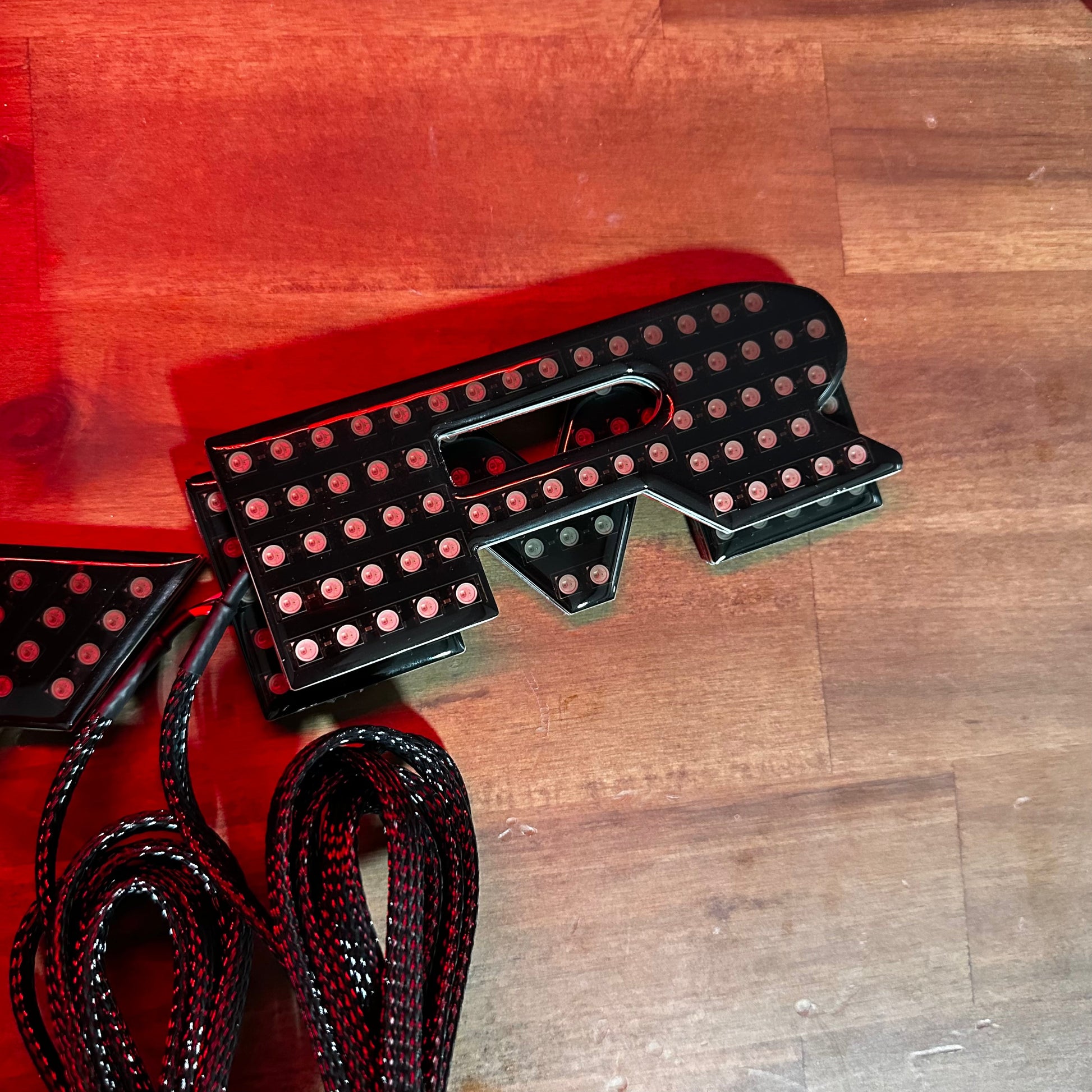 RAM RGBW Flow LED badge emblems in black housing with red glow for interior exterior use on Tampa Home & Garden Store