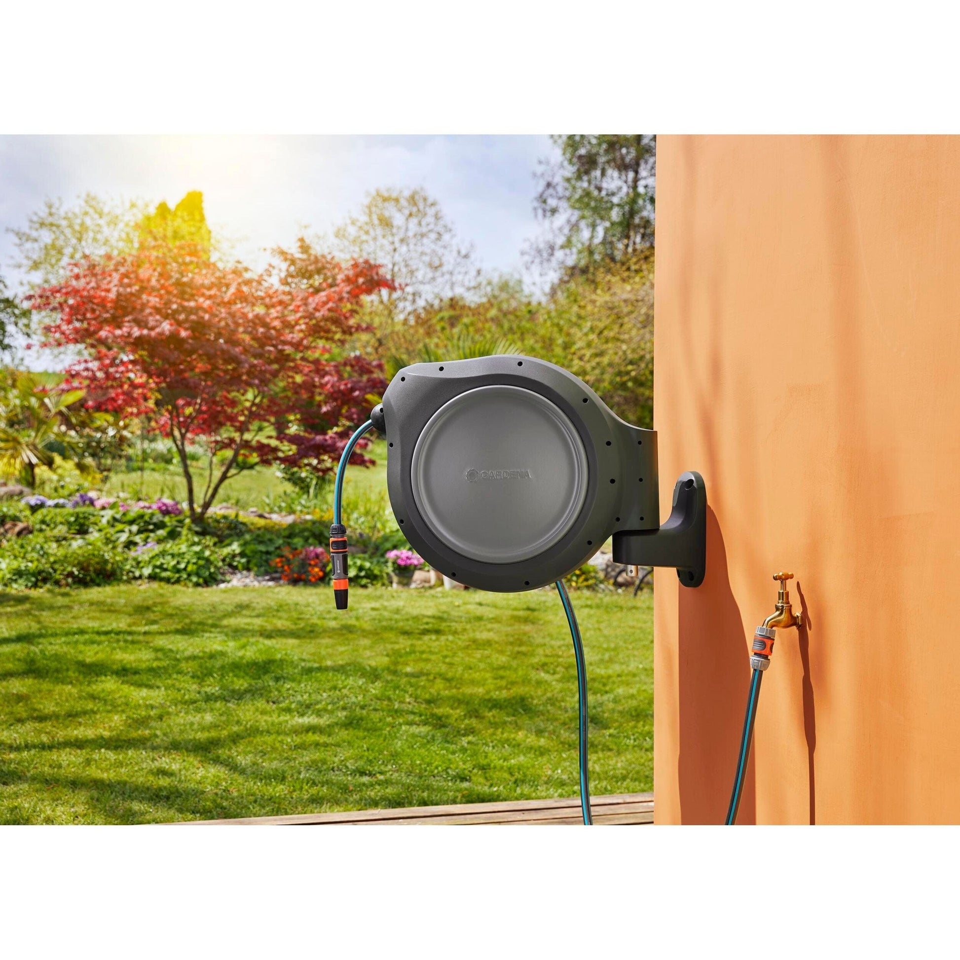 Gardena Retractable Hose Reel RollUp 100 ft gray housing with blue hose mounted outdoors on wood wall on Tampa Home & Garden Store