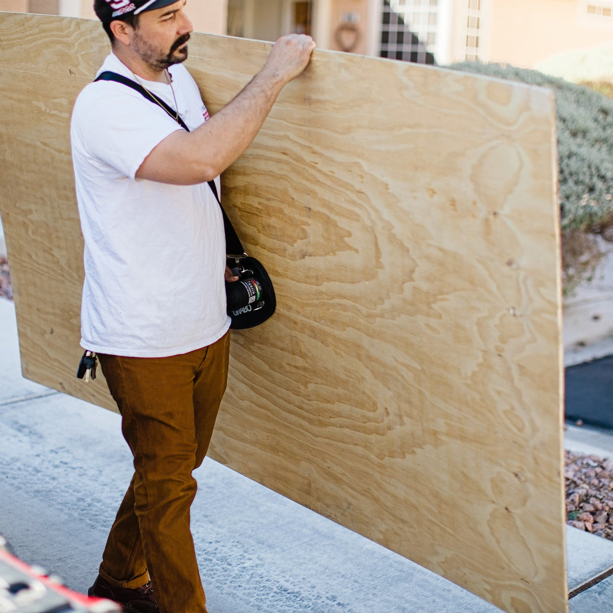 Lifting Strap suction grip accessory by GRIP TECH TOOLS carried by worker holding plywood on Tampa Home & Garden Store