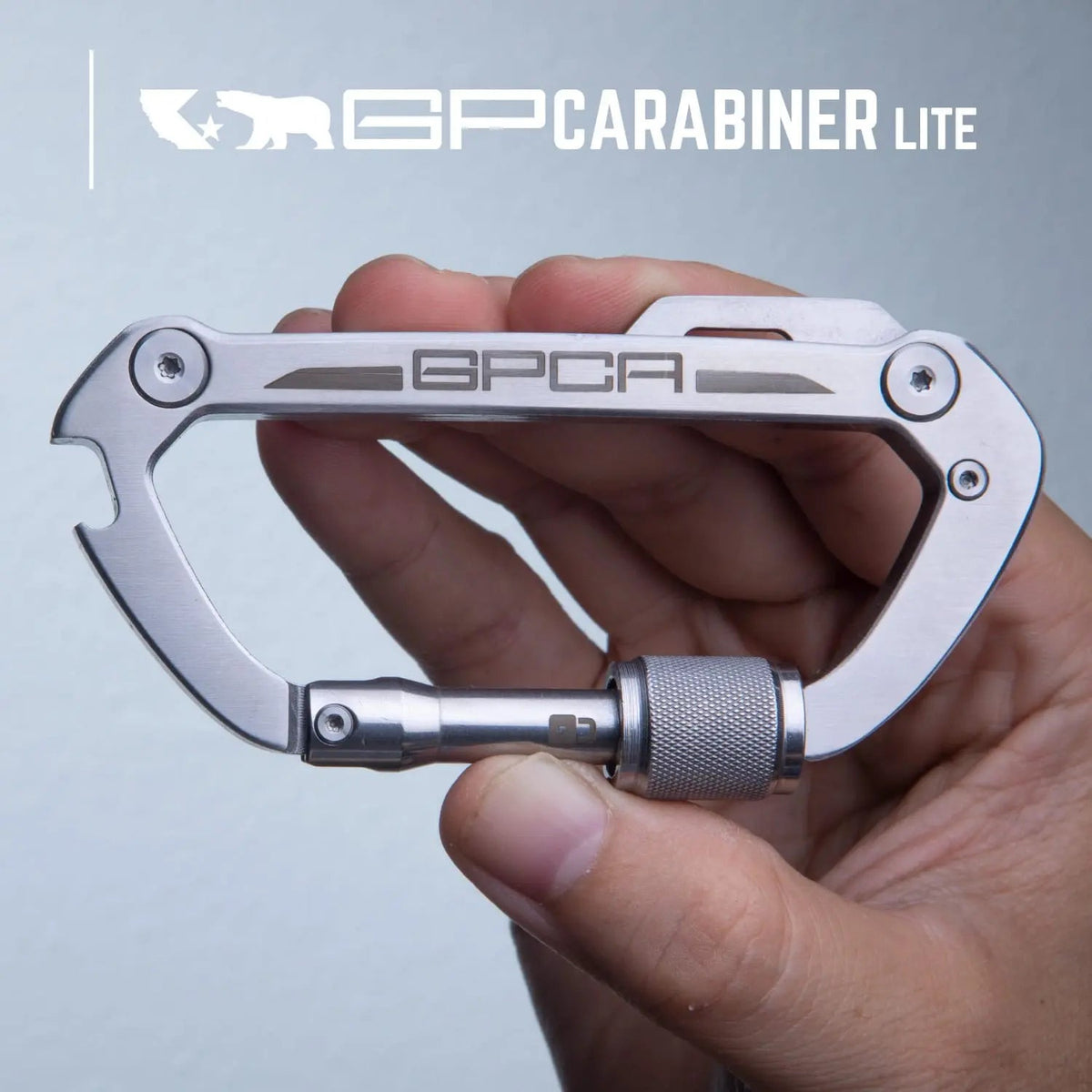 GPCA Carabiner Lite EDC keychain in silver stainless steel with GPCA logo held in hand on Tampa Home & Garden Store