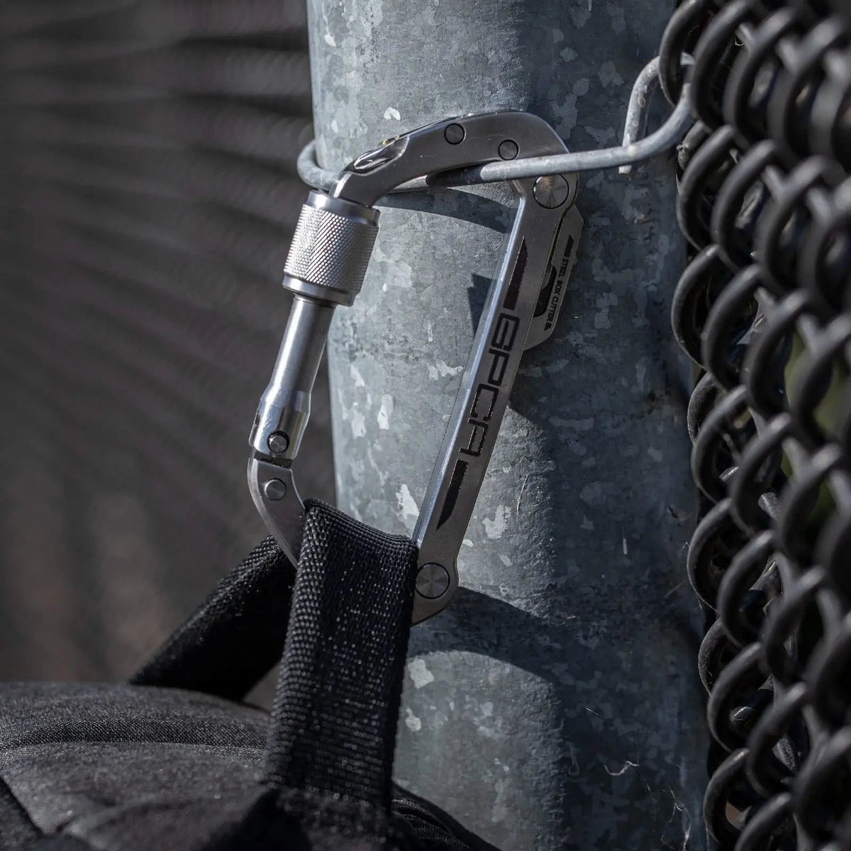 GPCA Carabiner PRO EDC multi-tool clip in stainless steel attached to metal post on Tampa Home & Garden Store