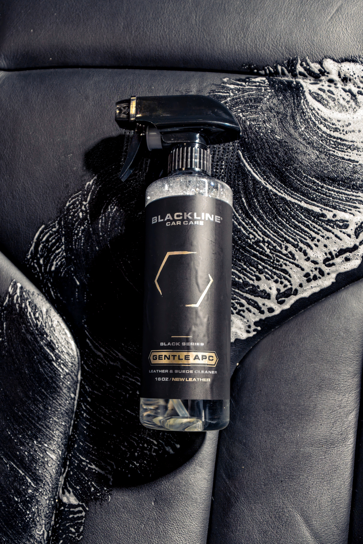 BLACKLINE Gentle APC all-purpose cleaner spray bottle on black leather car seat with soap suds on Tampa Home & Garden Store