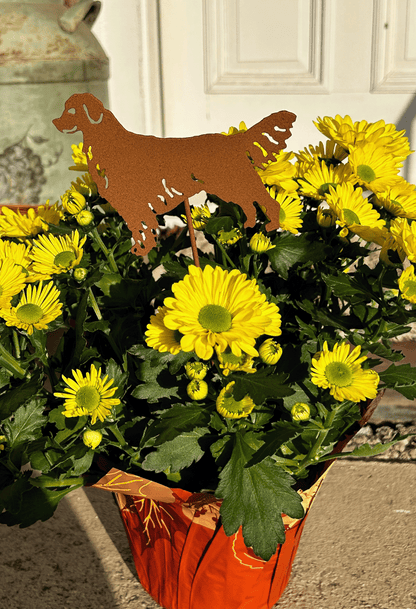 Golden Retriever plant stake in rusty metal finish among yellow mums in orange pot on Tampa Home & Garden Store