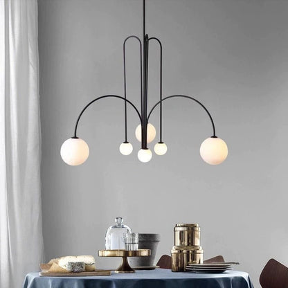 Globella 6-head pendant chandelier with glass globes, black metal arcs over dining table on Tampa Home & Garden Store