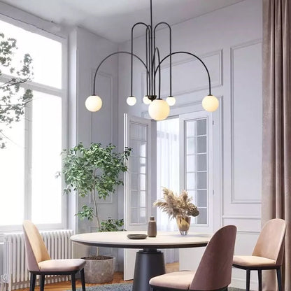 Globella 6-head pendant chandelier with glass globes, black curved arms over a dining table on Tampa Home & Garden Store