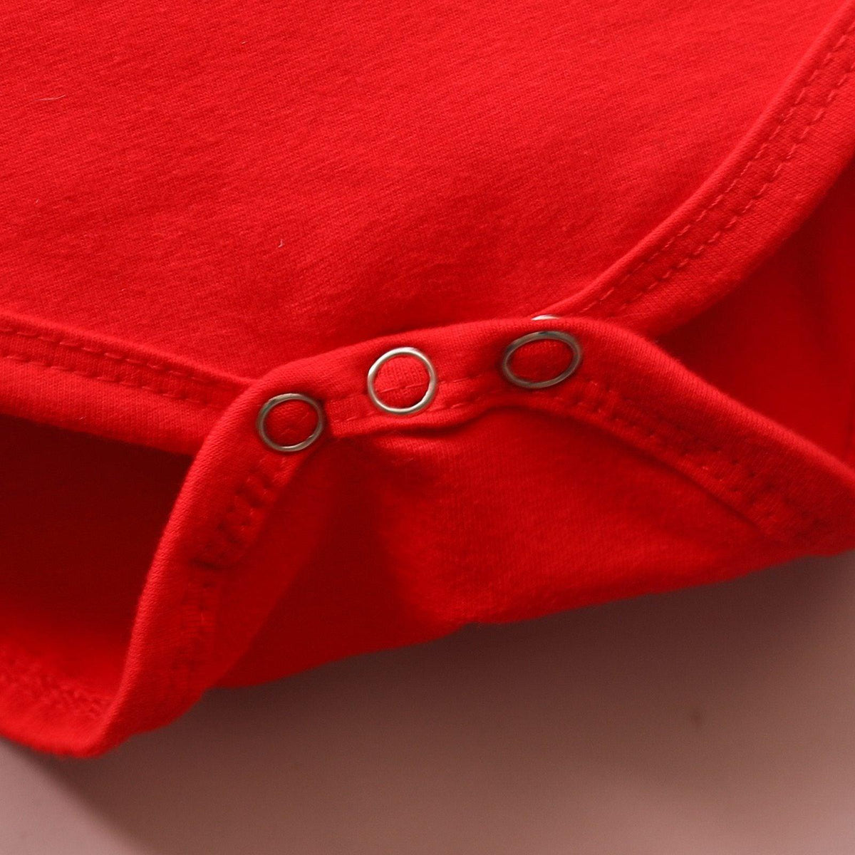 Red Stevvex newborn romper close-up with silver snap buttons along seam on Tampa Home & Garden Store