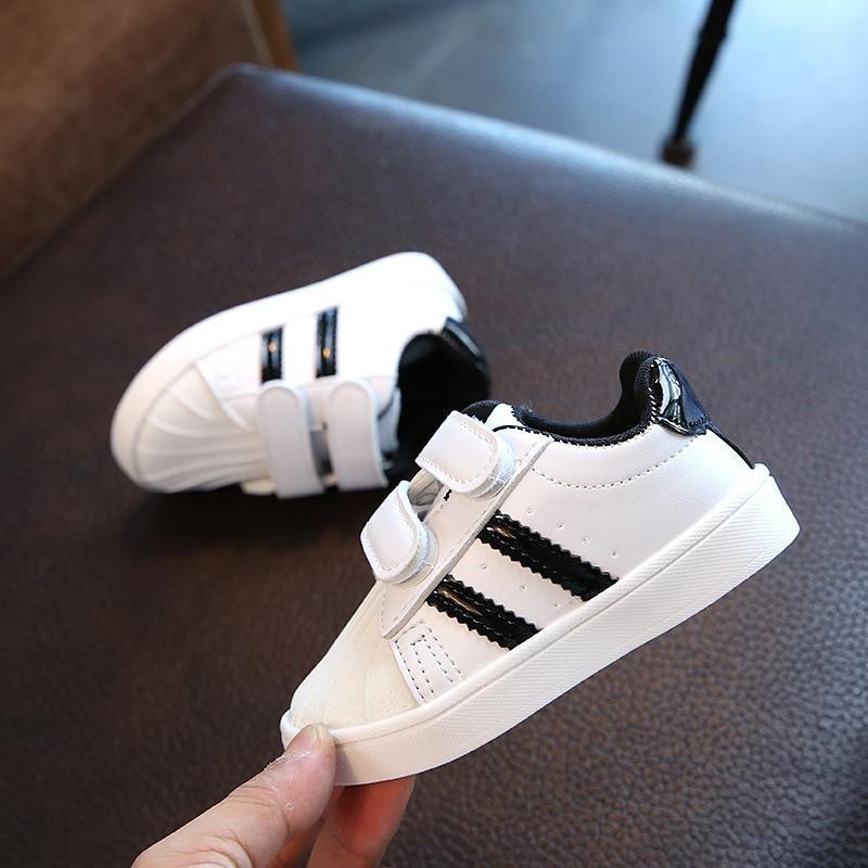 White toddler sneakers with black side stripes and two Velcro straps, rubber sole, 2 shoes on Tampa Home & Garden Store
