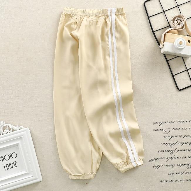 Stevvex beige kids sports pants with white side stripes and elastic cuffs on Tampa Home & Garden Store