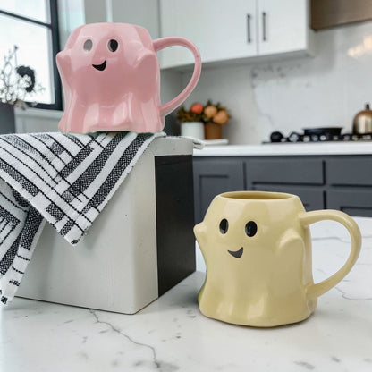Two pastel ghost mugs, pink and yellow ceramic coffee mugs on a kitchen counter on Tampa Home & Garden Store