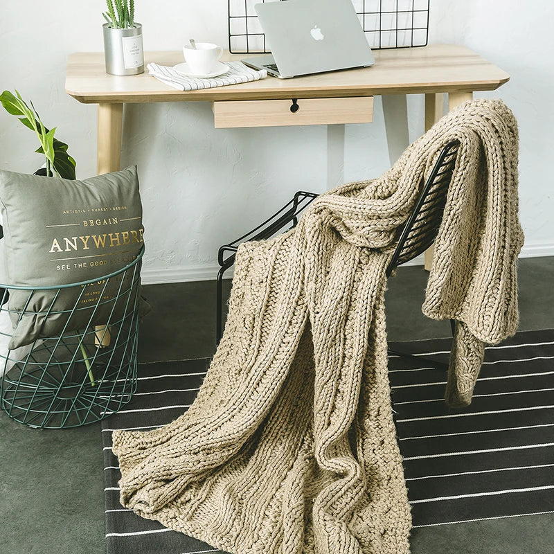 DecorBites Khaki Beige Chunky Knit Wool Blanket draped over a chair in a cozy home office on Tampa Home & Garden Store