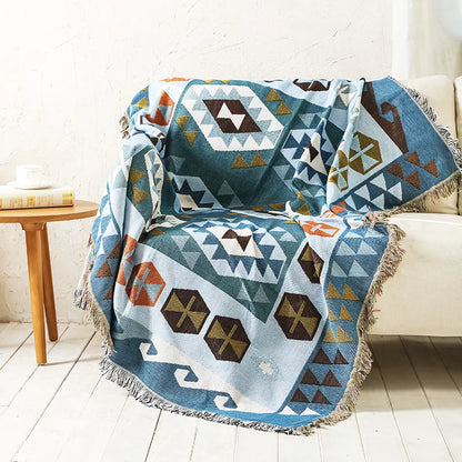 DecorBites knitted Nordic plaid blanket in teal blue with fringed edges on sofa on Tampa Home & Garden Store