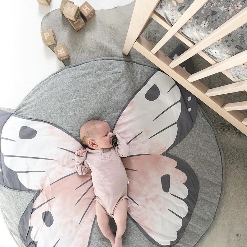 Round cotton baby play mat with pink-gray butterfly wings; newborn resting on it on Tampa Home & Garden Store