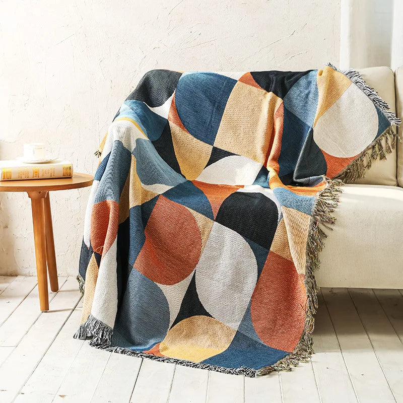 DecorBites knitted Nordic plaid blanket with multicolor circles draped over sofa with fringe on Tampa Home & Garden Store