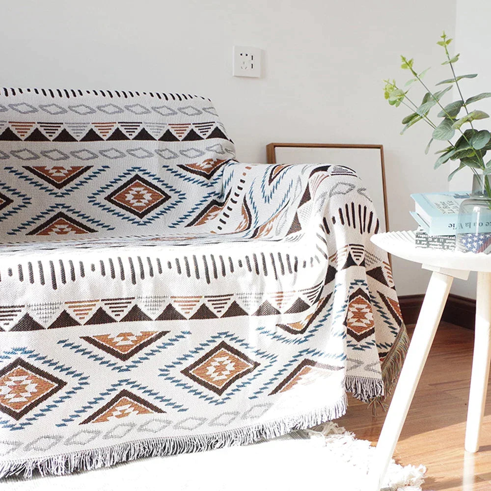 Decorbites knitted Nordic plaid blanket draped over sofa with white brown blue tones on Tampa Home & Garden Store