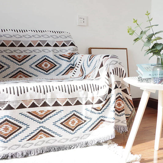 Decorbites knitted Nordic plaid blanket draped over sofa with white brown blue tones on Tampa Home & Garden Store
