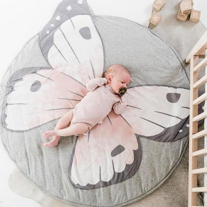 Round cotton baby play mat Stevvex with butterfly design gray and pink, baby resting on mat on Tampa Home & Garden Store