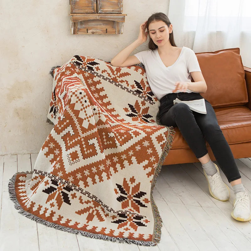 DecorBites knitted Nordic plaid blanket on a sofa in warm rust and ivory tones on Tampa Home & Garden Store