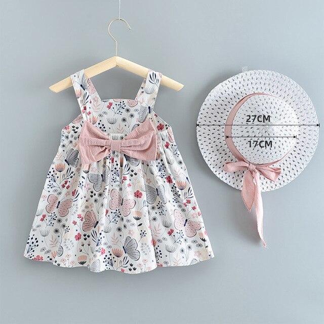 Baby girl dress and hat set with floral butterfly print and pink bow sash on a hanger on Tampa Home & Garden Store
