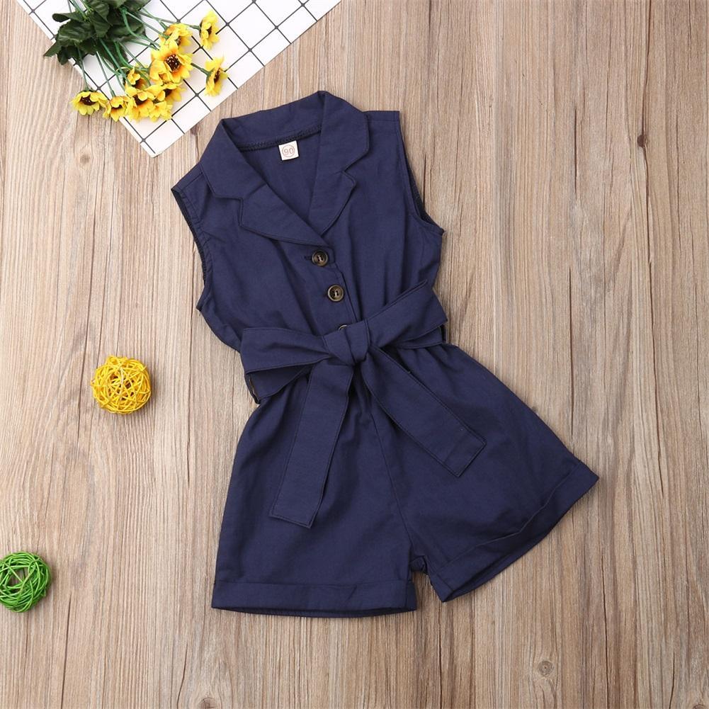 Navy blue girls romper jumpsuit with waist tie belt, front buttons and collared neckline on wood floor on Tampa Home & Garden Store