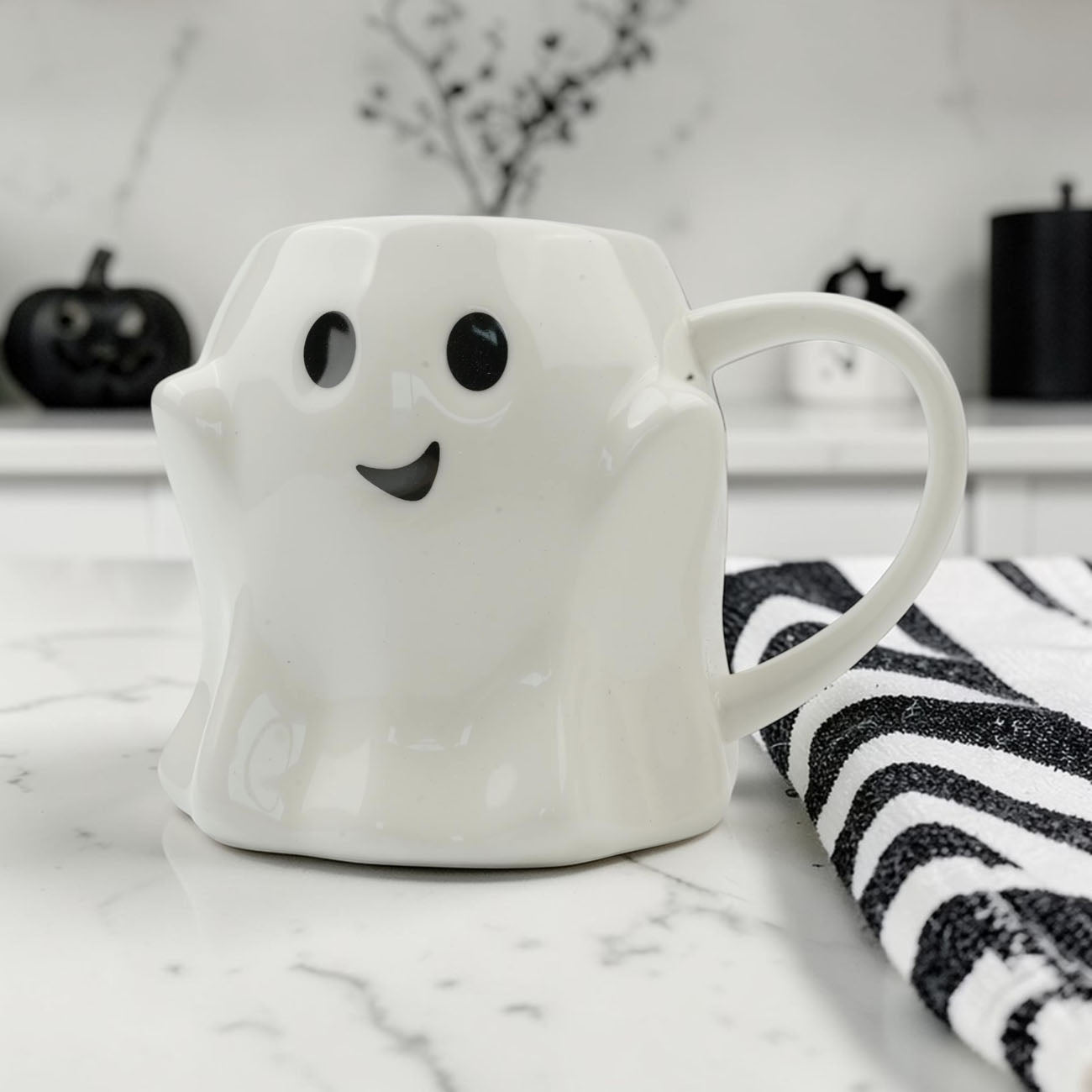 Ghost-shaped ceramic coffee mug, white glossy finish with black eyes and smile on Tampa Home & Garden Store