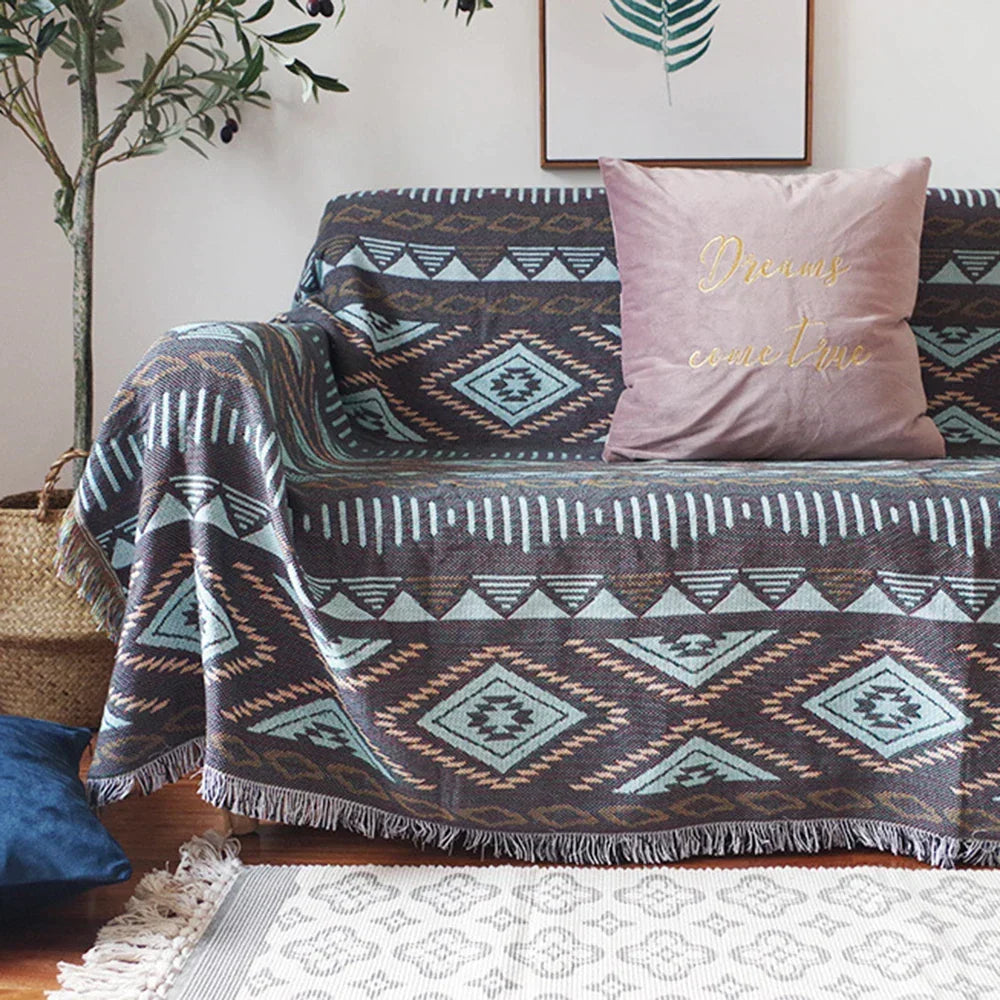 DecorBites Knitted Nordic Plaid Blanket on a sofa with teal, brown and ivory tones, pink cushion on Tampa Home & Garden Store