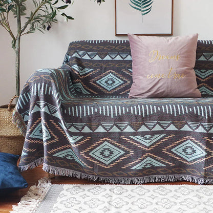 DecorBites Knitted Nordic Plaid Blanket on a sofa with teal, brown and ivory tones, pink cushion on Tampa Home & Garden Store