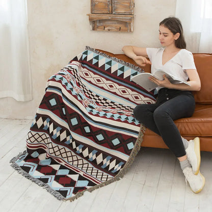 Decorbites knitted Nordic plaid blanket with fringe in burgundy and teal on sofa on Tampa Home & Garden Store