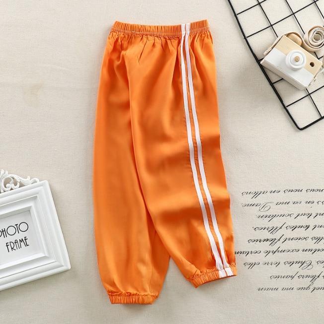 Kids orange sports pants Stevvex with white side stripes, elastic cuffs on Tampa Home & Garden Store