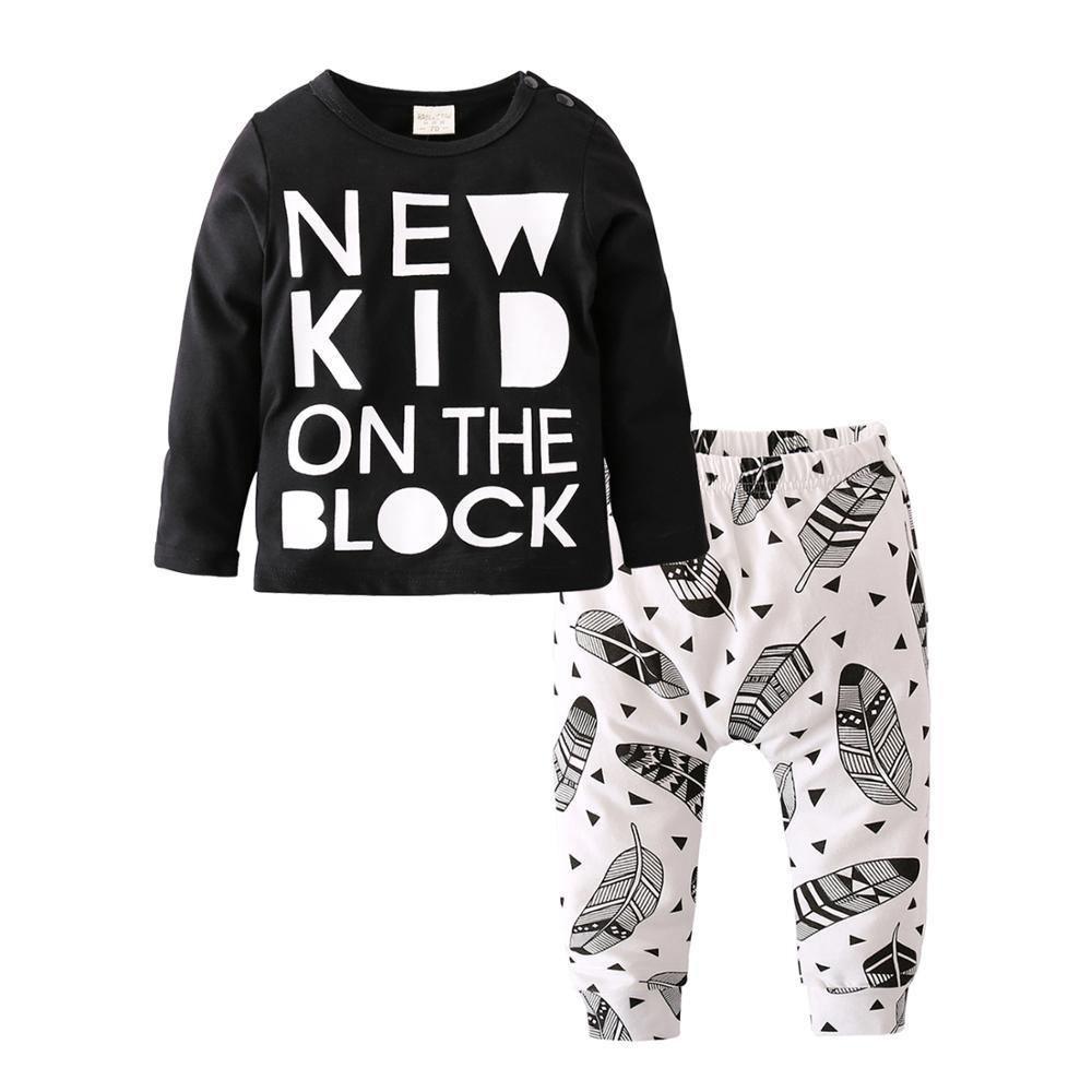 Newborn boy 2pc outfit: black long sleeve tee with white block text and white leaf-pattern pants on Tampa Home & Garden Store