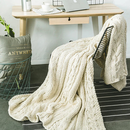 DecorBites Khaki Beige chunky knit wool blanket draped over a black metal chair on Tampa Home & Garden Store