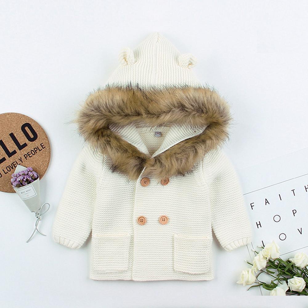 Stevvex white knit hooded baby coat with fur collar, wooden buttons and front pockets on Tampa Home & Garden Store