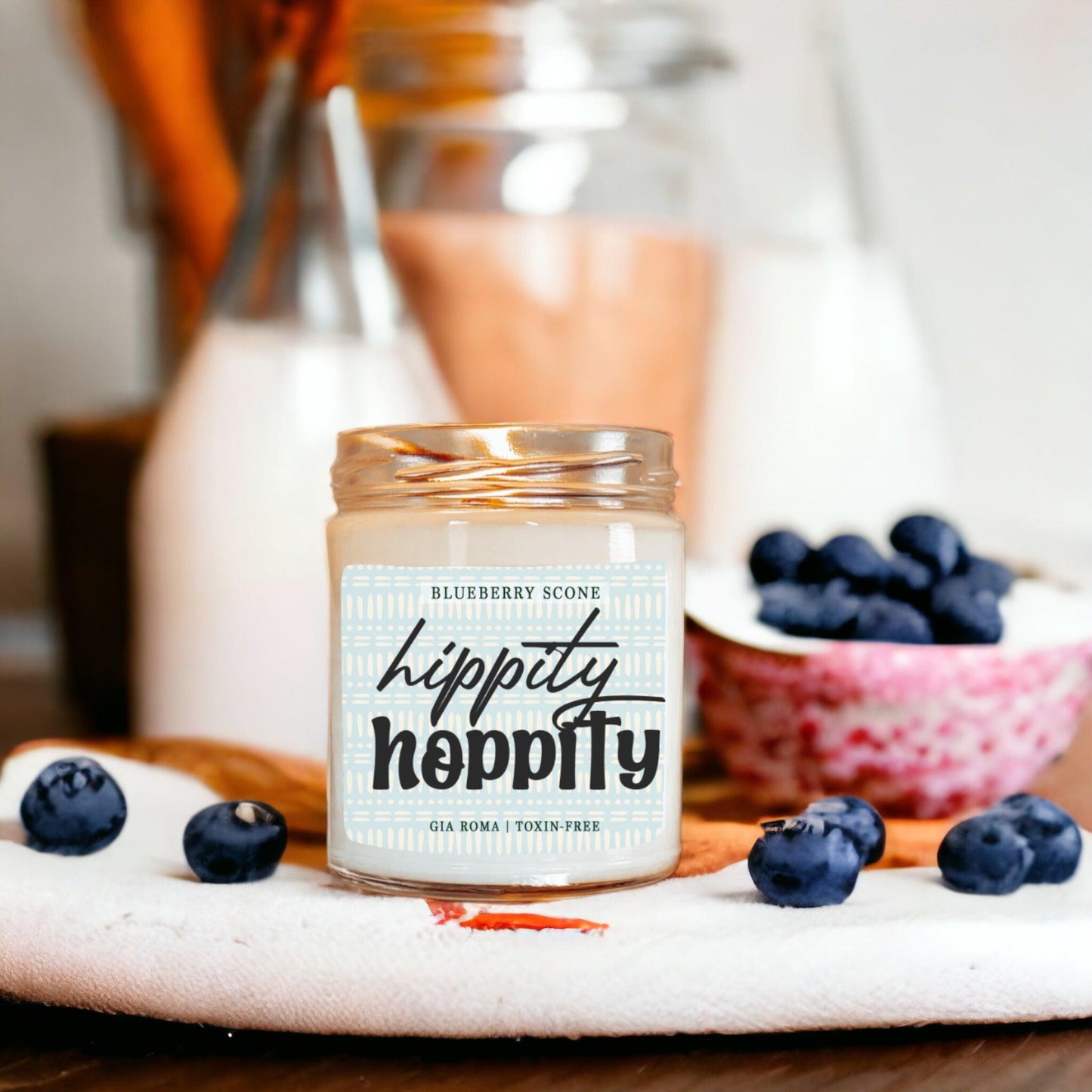 Gia Roma Blueberry Scone candle in a glass jar with copper lid, surrounded by blueberries on Tampa Home & Garden Store