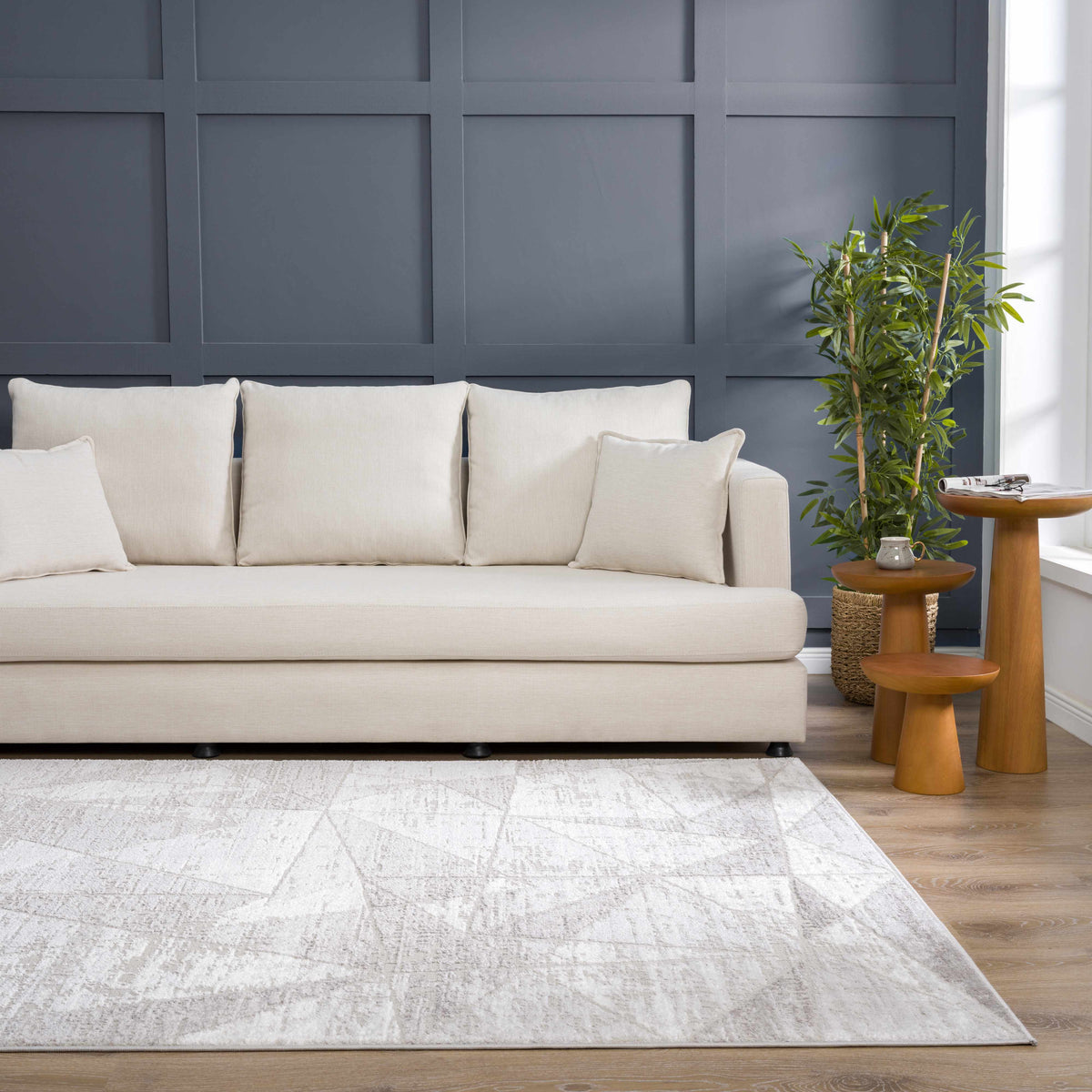 Basia Area Rug in soft beige with a subtle textured pattern, shown in a modern living room on Tampa Home & Garden Store