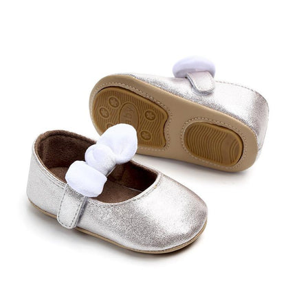 Pair of metallic silver baby shoes with white bowknot and soft rubber soles by Stevvex on Tampa Home & Garden Store