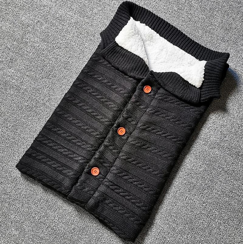 Stevvex baby swaddling sleeping bag, black quilted knit with white fleece lining and orange buttons on Tampa Home & Garden Store