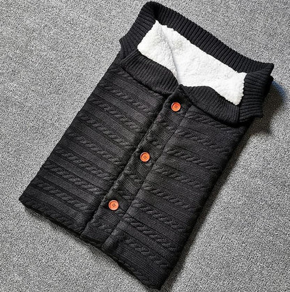Stevvex baby swaddling sleeping bag, black quilted knit with white fleece lining and orange buttons on Tampa Home & Garden Store
