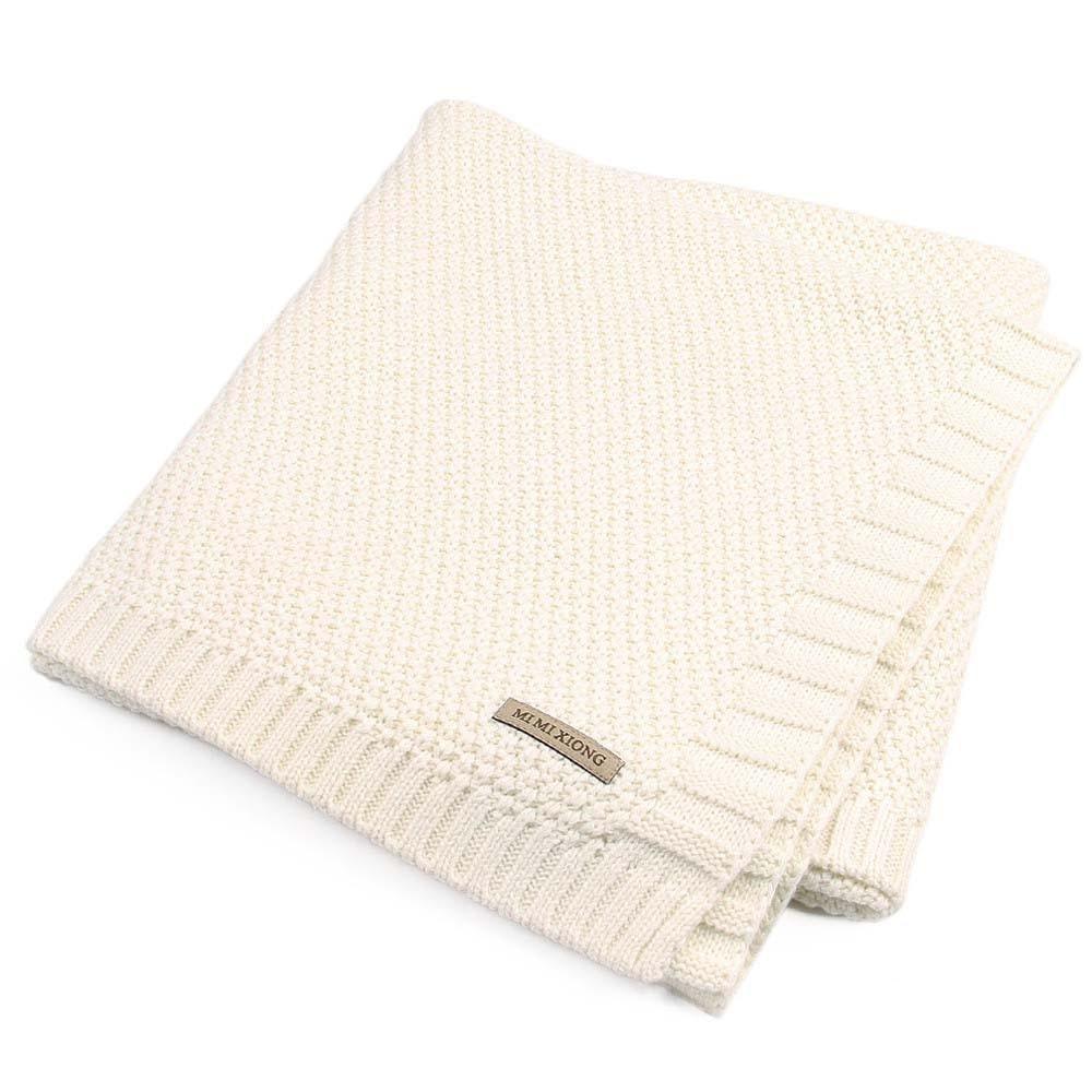 Baby knitted swaddle blanket cream color with ribbed edges and a brand tag on Tampa Home & Garden Store