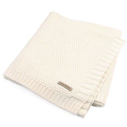 Baby knitted swaddle blanket cream color with ribbed edges and a brand tag on Tampa Home & Garden Store