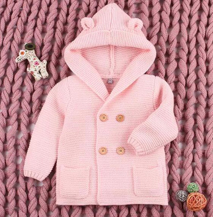 Pink knitted baby cardigan with hood featuring bear ears, double wooden buttons and pockets on Tampa Home & Garden Store