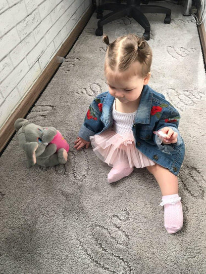 Stevvex jacket with rose embroidery on sleeves worn by baby girl beside a plush elephant on Tampa Home & Garden Store